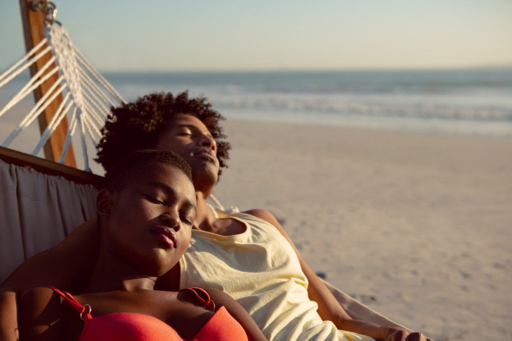 casal descansando em rede na praia durante viagem no rio de janeiro